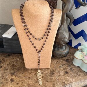 Brown wired double necklace with golden crystal charm that’s flexible like fish